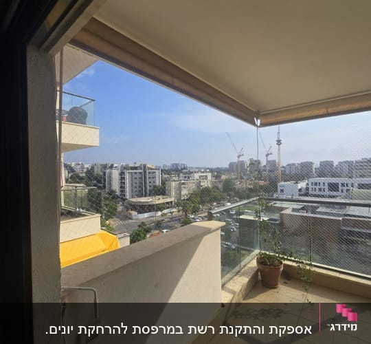 רשת יונים מותקנת במרפסת עם נוף עירוני
